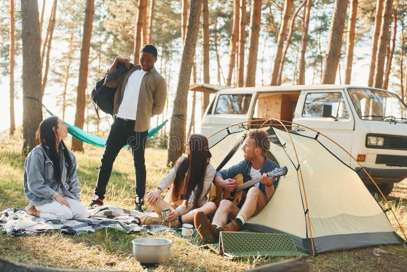 Läger och bilar. Ungdomsgruppen reser tillsammans i skogen på dagtid royaltyfria bilder