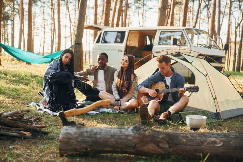 Läger och bilar. Ungdomsgruppen reser tillsammans i skogen på dagtid royaltyfri foto