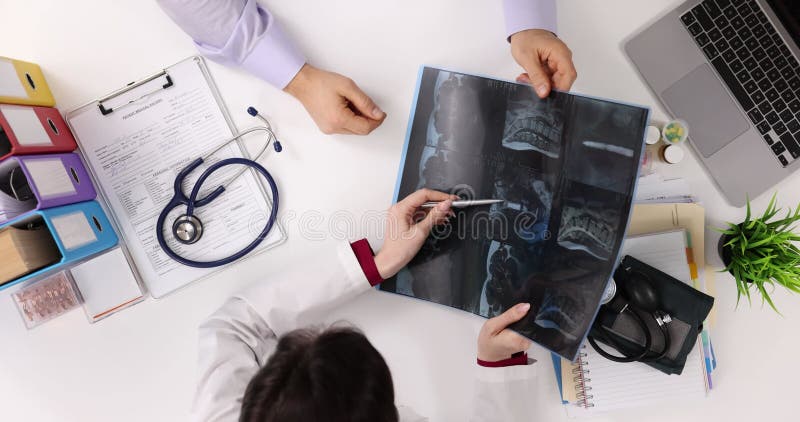 Läkare undersöker en röntgenbild under ett patientsamråd arkivfilmer