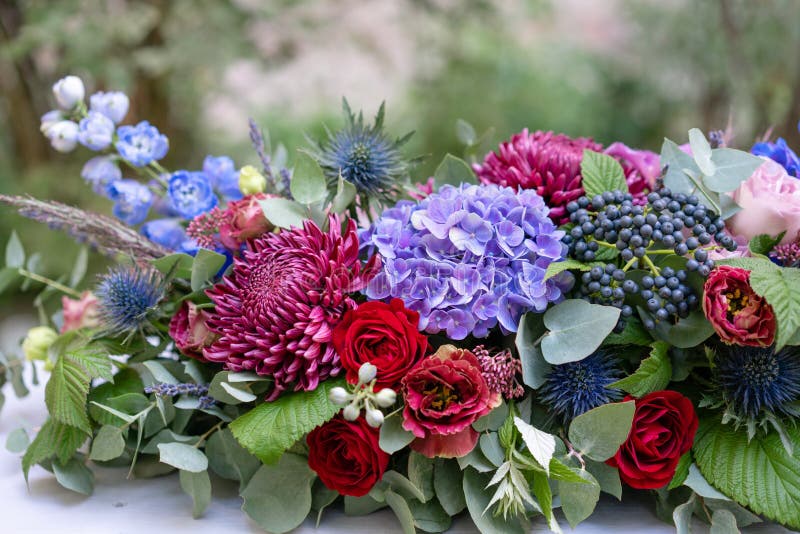Längliches Blumengesteck im Weinlesemetallvase Legen Sie Einstellung ver blaue und rote Farbe Herrlicher Blumenstrauß von untersc