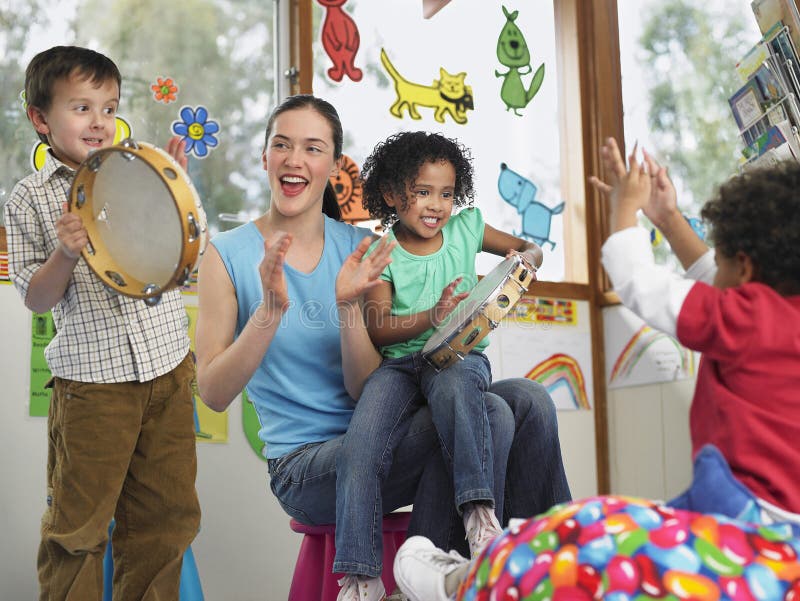 LärareWith Children Playing musik i grupp royaltyfri bild