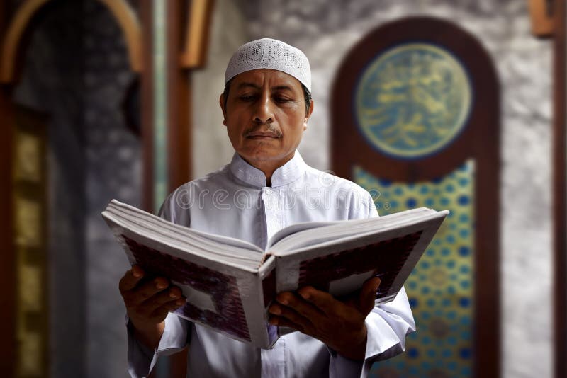 Läs- Koranen för gammal muslimman royaltyfri foto Läs- Koranen för gammal muslimman royaltyfri foto