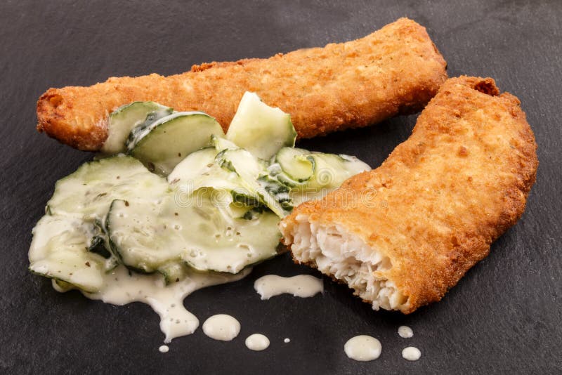 Lätt panerade torskfiléer och gurksallad royaltyfri foto