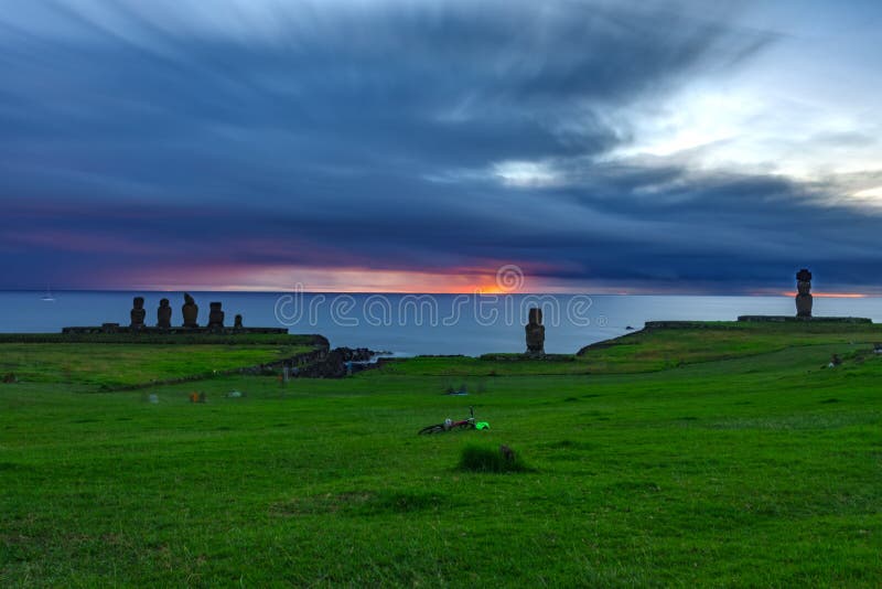 Lång exponering av Moais i Ahuen Tahai på solnedgången mot djup molnig himmel royaltyfri fotografi Lång exponering av Moais i Ahuen Tahai på solnedgången mot djup molnig himmel royaltyfri fotografi