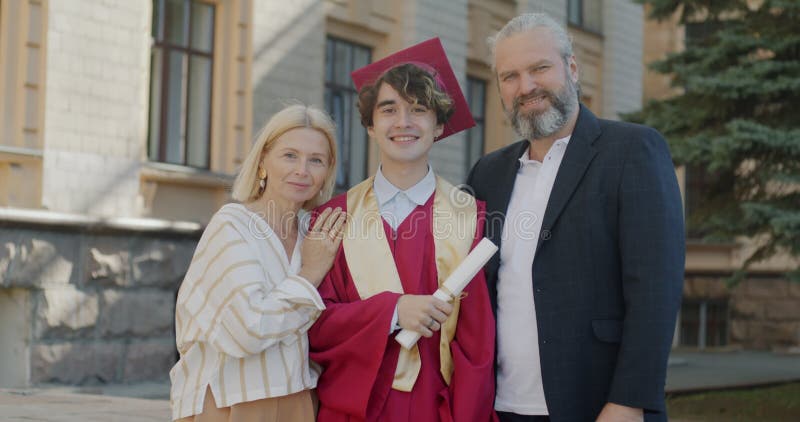 Långsam rörelse av unga manliga studenter och föräldrar som står på universitetscampus på universitetsdag