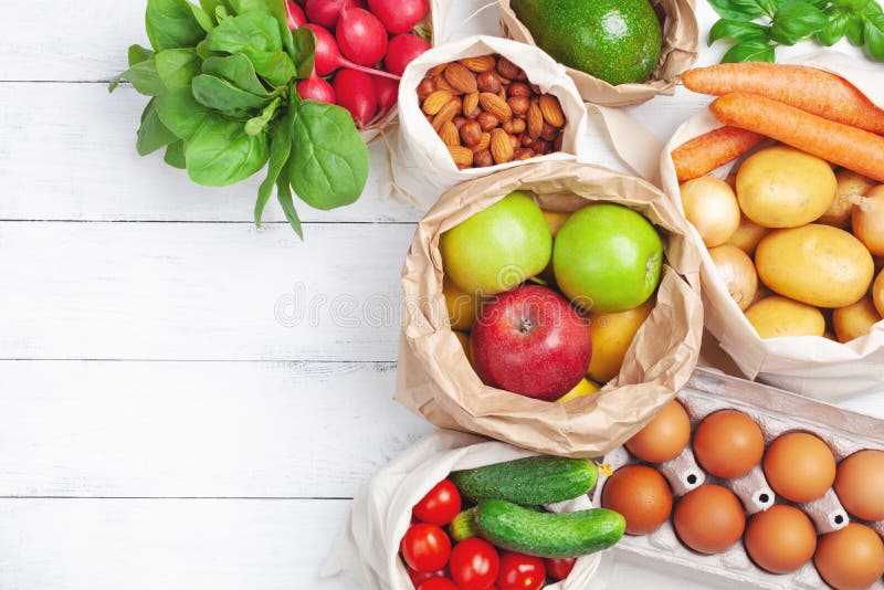 Fresh vegetables and fruits in natural eco friendly cotton and paper bags top view. Zero waste food shopping and plastic free concept. Fresh vegetables and fruits in natural eco friendly cotton and paper bags top view. Zero waste food shopping and plastic free concept