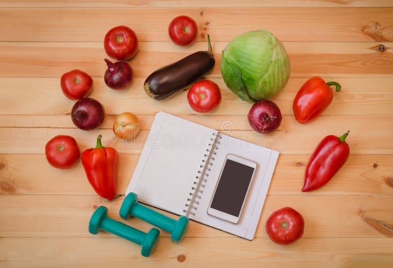 L?gumes frais, halt?res vertes, carnet et smartphone sur le fond en bois Concept sain de style de vie image libre de droits L?gumes frais, halt?res vertes, carnet et smartphone sur le fond en bois Concept sain de style de vie image libre de droits
