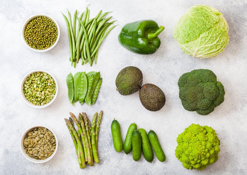 Légumes organiques crus modifiés la tonalité verts assortis sur le fond blanc Avocat, chou, brocoli, chou-fleur et concombre avec images stock Légumes organiques crus modifiés la tonalité verts assortis sur le fond blanc Avocat, chou, brocoli, chou-fleur et concombre avec images stock