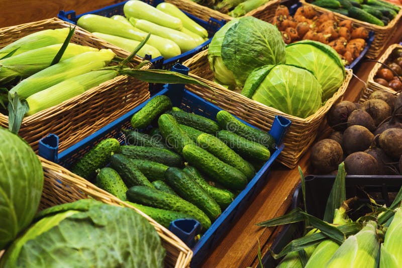 Légumes verts frais dans les paniers en osier sur le compteur d'un petit marché végétal photos libres de droits Légumes verts frais dans les paniers en osier sur le compteur d'un petit marché végétal photos libres de droits