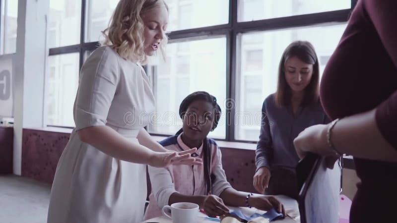 Líder de equipo africano joven que camina a través del trabajo moderno de la oficina y de los controles del empleado La hembra mi almacen de metraje de vídeo Líder de equipo africano joven que camina a través del trabajo moderno de la oficina y de los controles del empleado La hembra mi almacen de metraje de vídeo