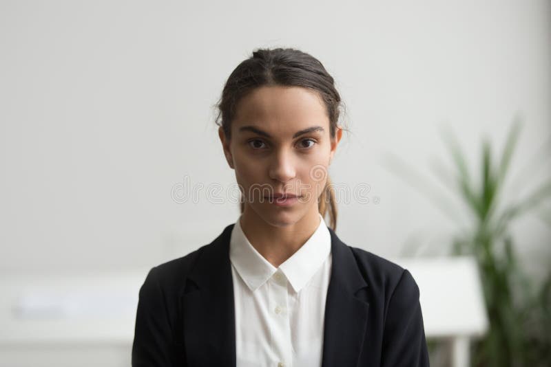 Líder empresarial serio de la mujer joven que mira la cámara, headshot imagenes de archivo Líder empresarial serio de la mujer joven que mira la cámara, headshot imagenes de archivo