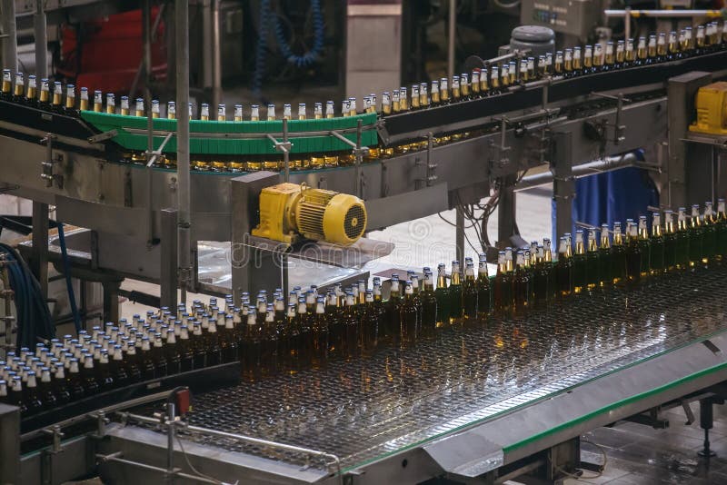 Línea o correa automática del transportador con las botellas de cristal en la producción de la cervecería Maquinaria embotell foto de archivo libre de regalías Línea o correa automática del transportador con las botellas de cristal en la producción de la cervecería Maquinaria embotell foto de archivo libre de regalías