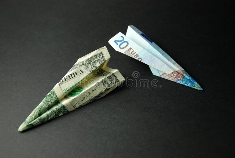 Two paper planes made from an American $1 bill and a €20 note. Two paper planes made from an American $1 bill and a €20 note.