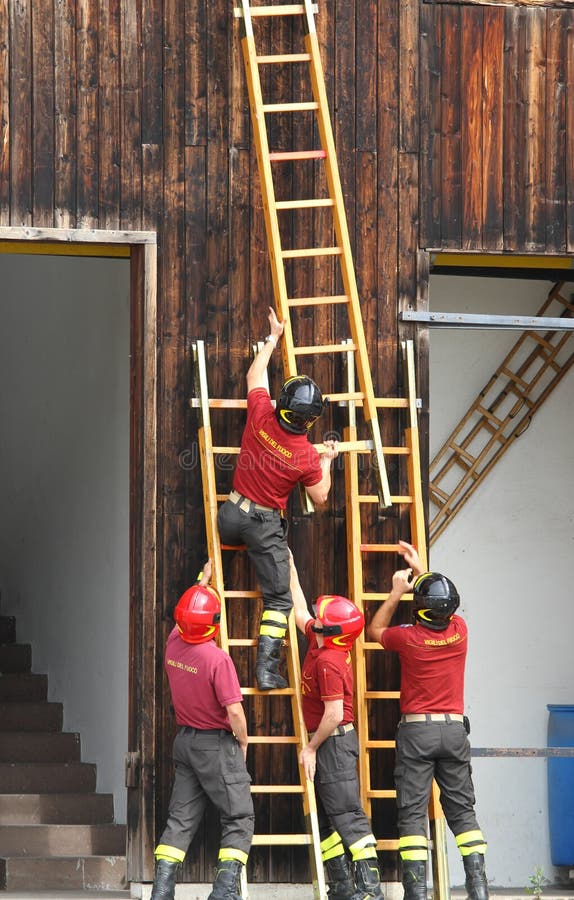 Löschmannschaft während der schnellen hölzernen Leiter des Brandschutzübungsbergs stockfotografie Löschmannschaft während der schnellen hölzernen Leiter des Brandschutzübungsbergs stockfotografie