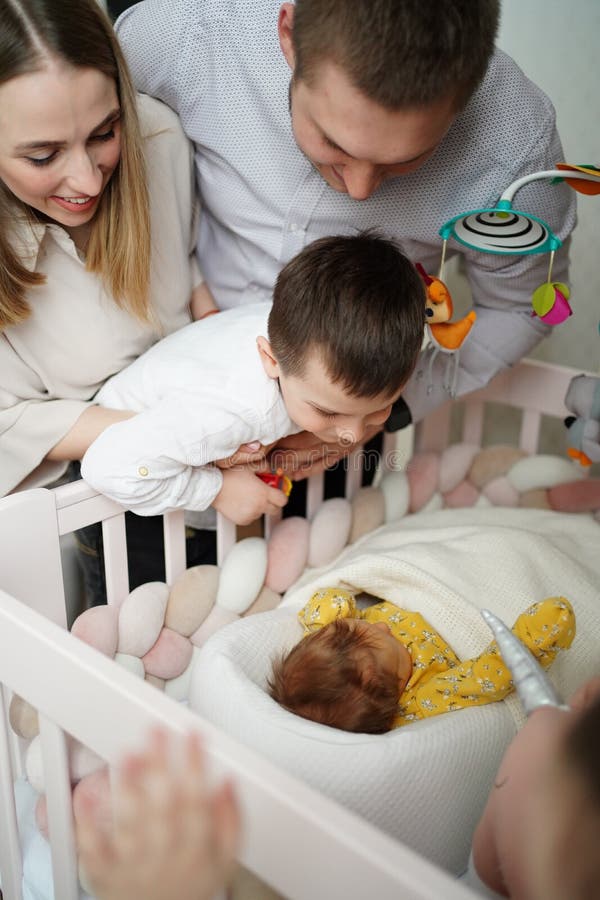 Mãe Ajuda Um Bebê Recém Nascido a Sentar. Criança Gritando Na Sala De Jogos  Em Um Chão De Espuma Mole Foto de Stock - Imagem de gritar, casa: 215291796