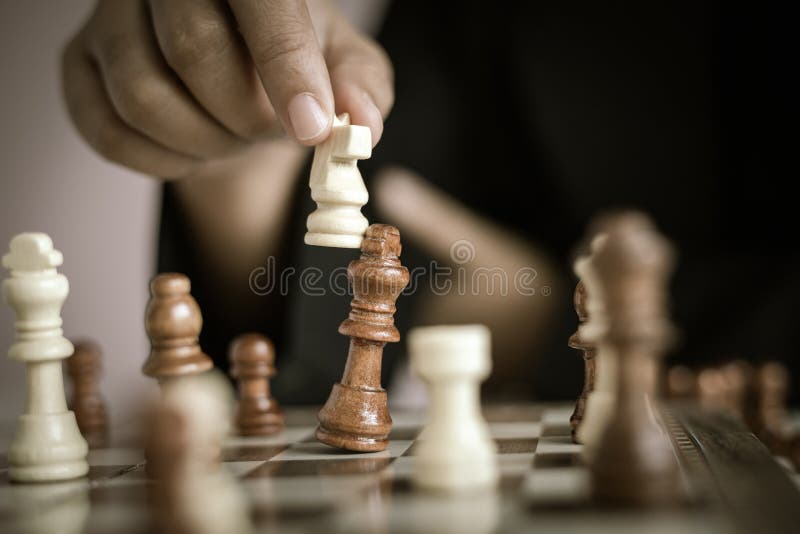 Mão usando um rei de ouro xadrez é matar um rei de prata xadrez.