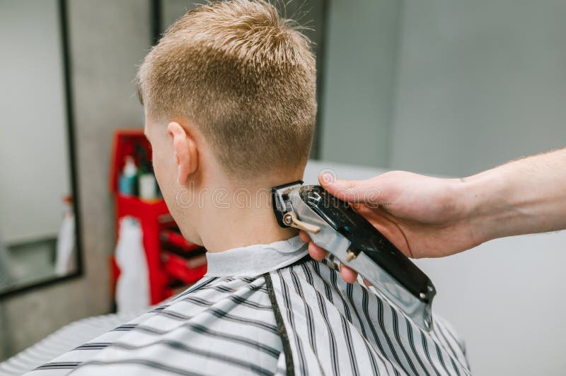 Cabeleireiro Fêmea Que Faz O Corte De Cabelo Masculino Com a