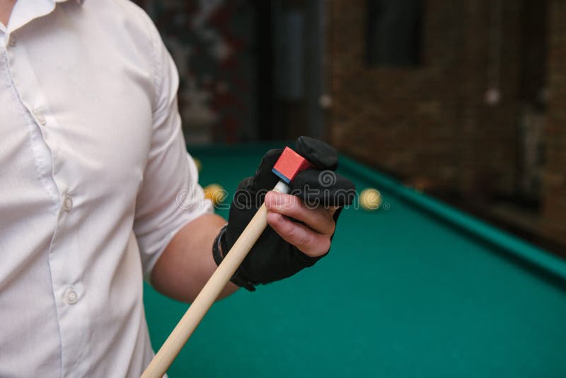 Mão do homem jogando sinuca no bar com bola de snooker