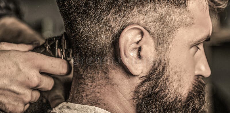 Homem moreno com corte de cabelo elegante no fundo da barbearia