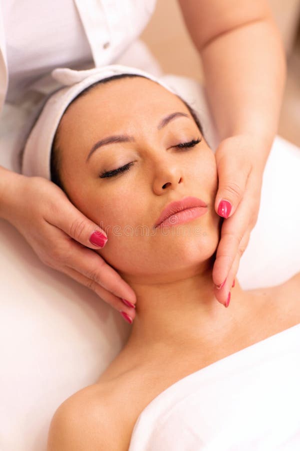Mestre feminino qualificado mestre profissional forte fazendo massagem nas pernas para cliente feminino