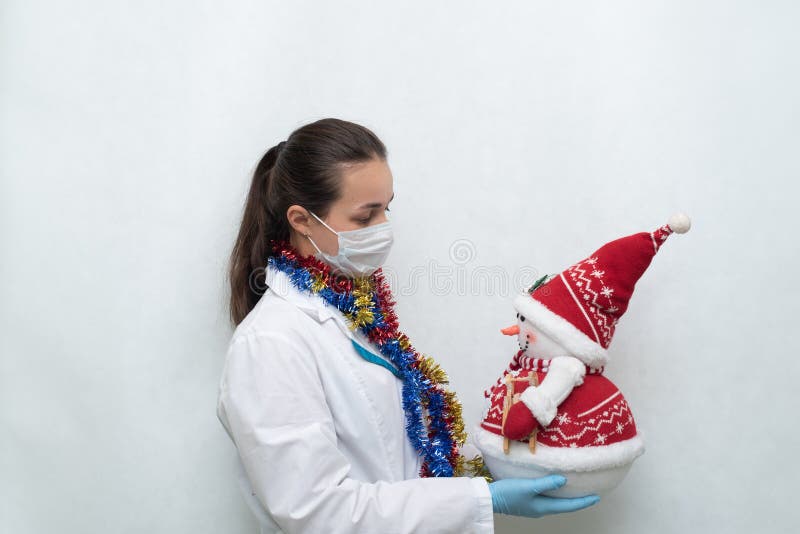 Médico De La Mujer Con El Mono De Nieve De Navidad En Manos Sobre Fondo Blanco Imagen de archivo Imagen de hermoso, alegre: 202841385