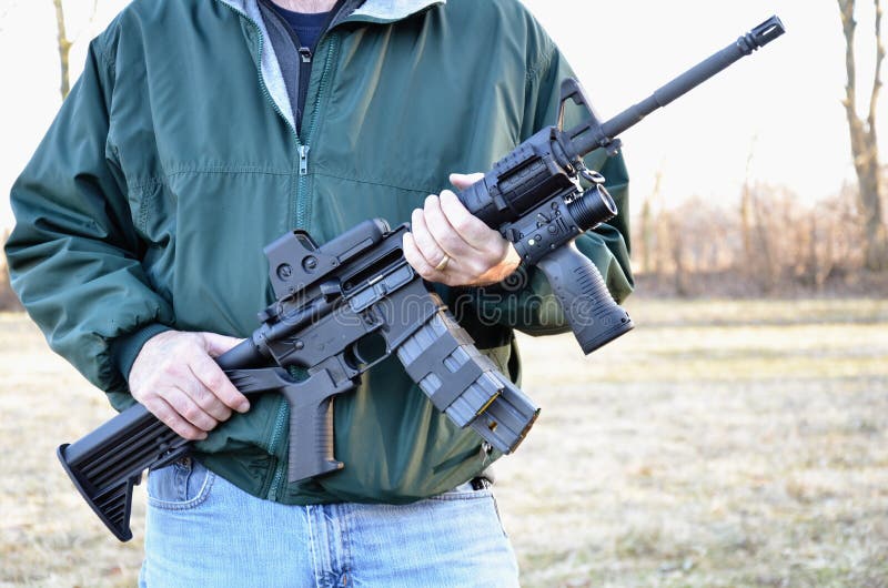 Man holding M-4 Semi-Automatic Rifle with clip. Man holding M-4 Semi-Automatic Rifle with clip.