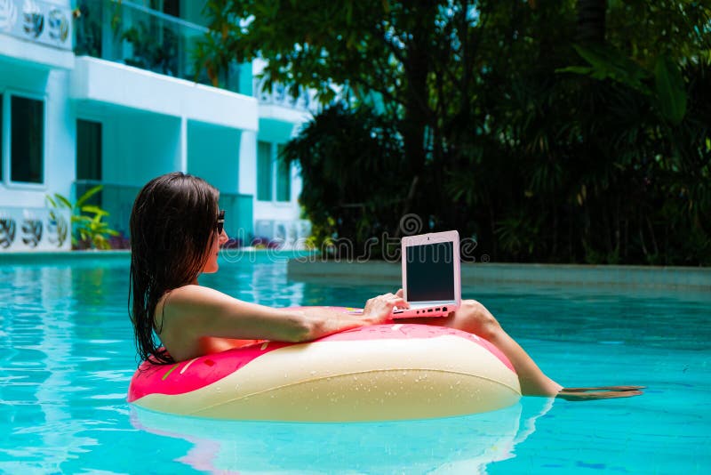 M?dchen im aufblasbaren Kreis im Pool mit einem Laptop, im Konzept des Freiberuflich t?tig seins und in der Erholung stockfotos M?dchen im aufblasbaren Kreis im Pool mit einem Laptop, im Konzept des Freiberuflich t?tig seins und in der Erholung stockfotos