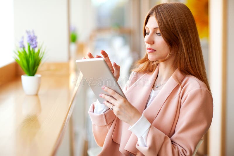M?dchenfreiberufler, der eine Tablette im Caf? h?lt stockfoto M?dchenfreiberufler, der eine Tablette im Caf? h?lt stockfoto