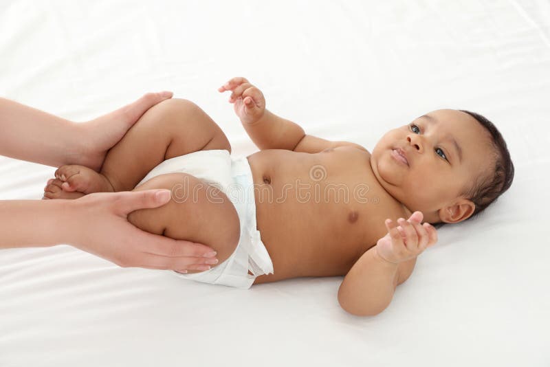 M?e e sua crian?a bonito na cama branca Massagem do beb?