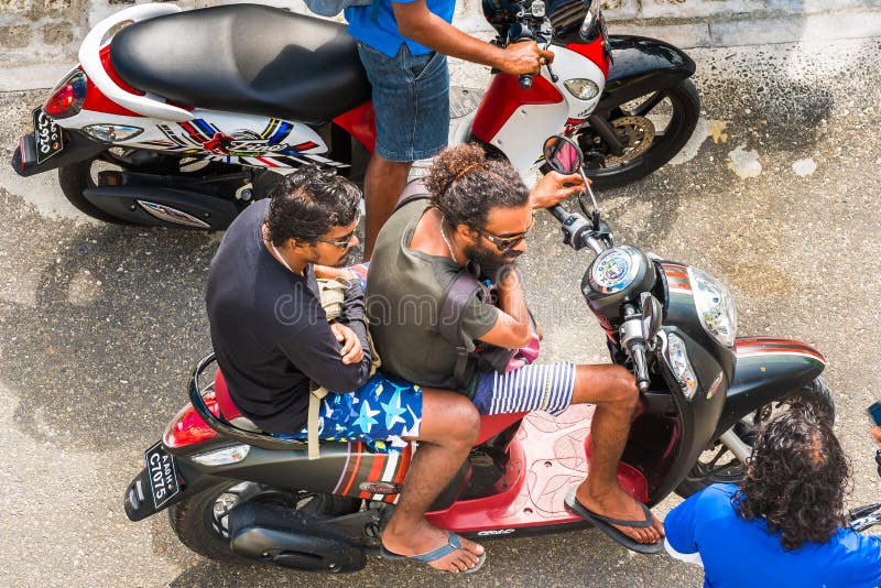 MÂLE, MALDIVES - NOVEMBRE, 27, 2016 : Un homme sur une moto sur la rue de ville Vue supérieure Plan rapproché photos libres de droits MÂLE, MALDIVES - NOVEMBRE, 27, 2016 : Un homme sur une moto sur la rue de ville Vue supérieure Plan rapproché photos libres de droits