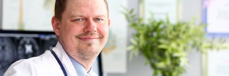 M?nnlicher Doktor im B?ro, das in camera l?chelnd schaut lizenzfreie stockfotos M?nnlicher Doktor im B?ro, das in camera l?chelnd schaut lizenzfreie stockfotos