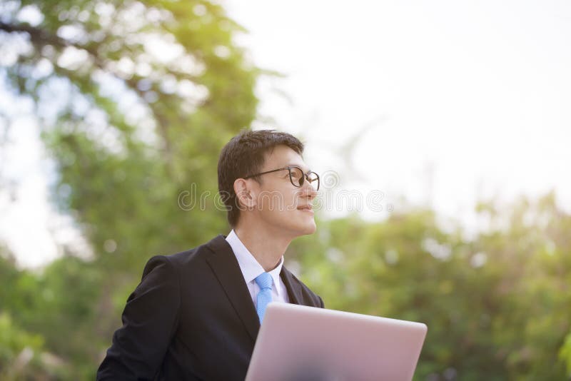 M?ody szcz??liwy i pomy?lny biznesmen ono u?miecha si? podczas jego br i obraz stock M?ody szcz??liwy i pomy?lny biznesmen ono u?miecha si? podczas jego br i obraz stock