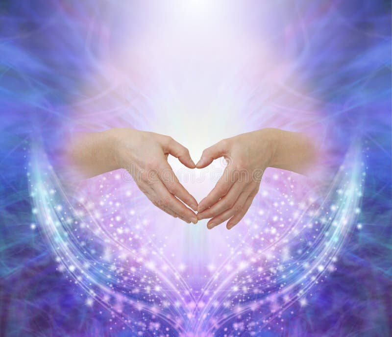Female hands forming a heart shape against a pink circle surrounded by ethereal blue and beautiful glittering sparkles with copy space above. Female hands forming a heart shape against a pink circle surrounded by ethereal blue and beautiful glittering sparkles with copy space above