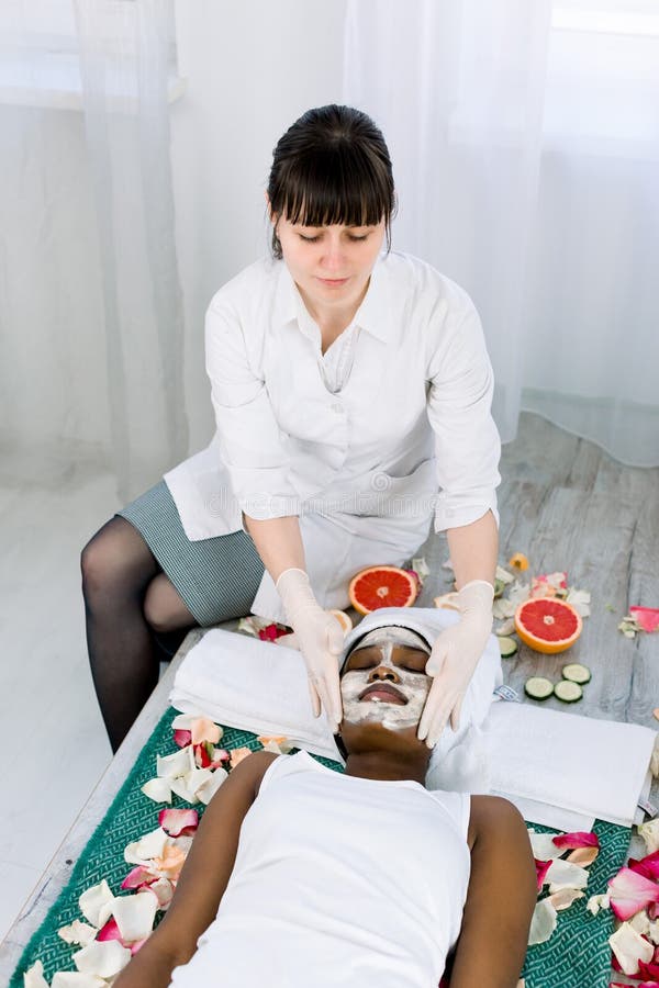 M?scara de la peladura de la cara, tratamiento de la belleza del balneario, skincare Mujer africana bonita que consigue cuidado f foto de archivo M?scara de la peladura de la cara, tratamiento de la belleza del balneario, skincare Mujer africana bonita que consigue cuidado f foto de archivo