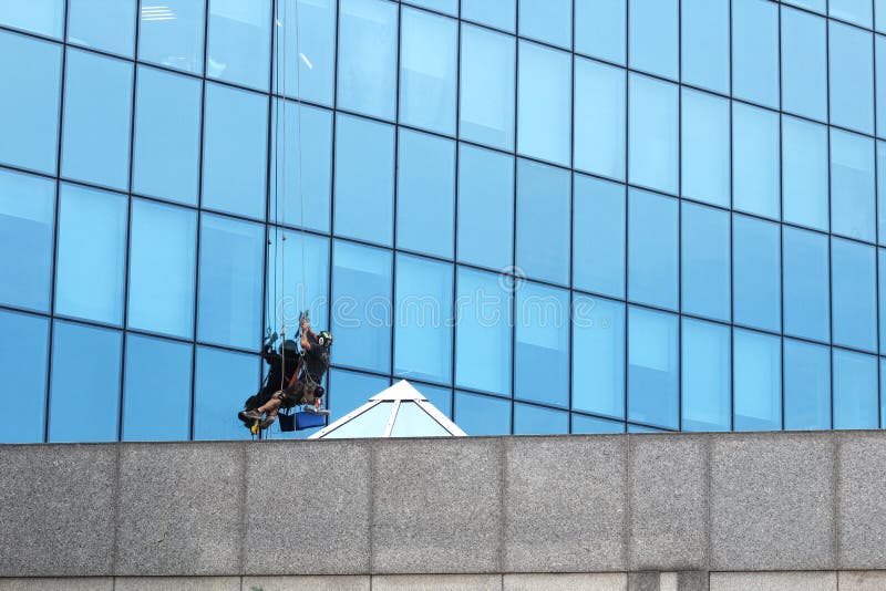 M?ski pracownik w kombinezonu profesjonalisty naprawie okno w wie?owu Pracowników płuczkowi okno w budynku biurowym Płuczki obmyc zdjęcie stock M?ski pracownik w kombinezonu profesjonalisty naprawie okno w wie?owu Pracowników płuczkowi okno w budynku biurowym Płuczki obmyc zdjęcie stock