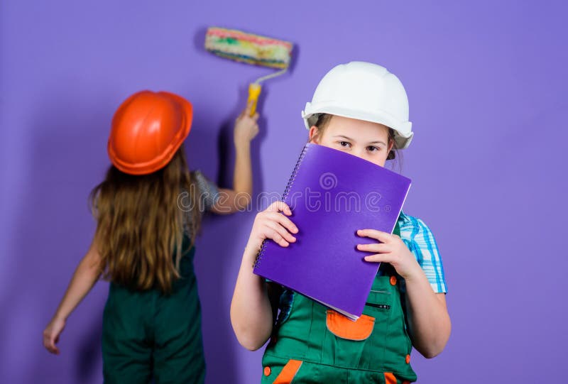 Small girls repairing together in workshop. Foreman inspector. Repair. Labor day. 1 may. engineering idea. Future career. Little kids in helmet with tablet and roller. What seems to be a problem