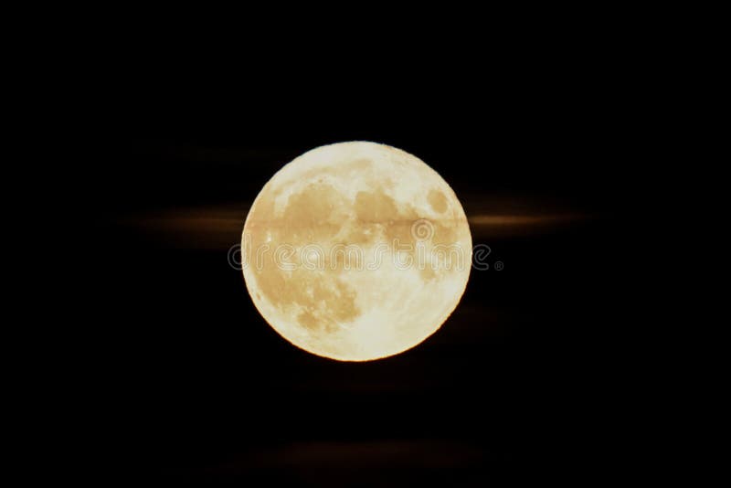 Moon at it largest also called supermoon approximately ten percent larger than usual with a tiny cloud behind it. Moon at it largest also called supermoon approximately ten percent larger than usual with a tiny cloud behind it
