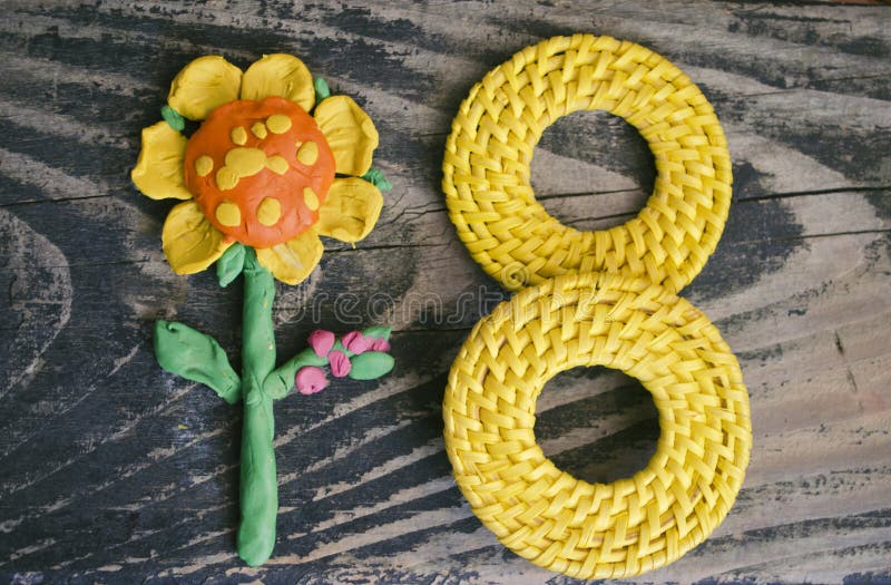 8 Maart-symbool en met de hand gemaakte plasticinebloem op houten achtergrond Het gelukkige ontwerp van de vrouwen` s dag Kan als stock foto's 8 Maart-symbool en met de hand gemaakte plasticinebloem op houten achtergrond Het gelukkige ontwerp van de vrouwen` s dag Kan als stock foto's
