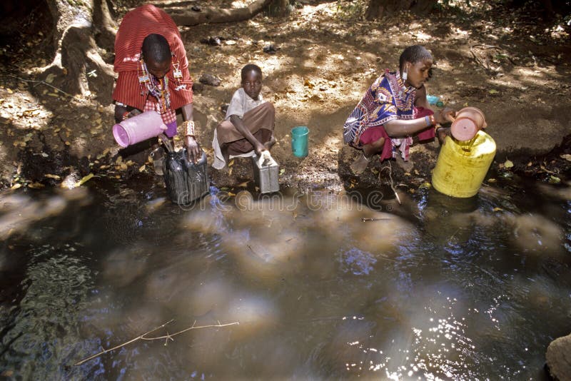 Maasai-Frauen, die Wasser im kleinen Strom holen stockfoto Maasai-Frauen, die Wasser im kleinen Strom holen stockfoto