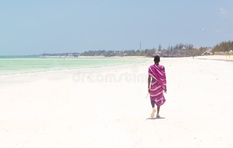 Maasai warrior walking on picture perfect tropical sandy beach. Paje, Zanzibar, Tanzania. royalty free stock photo Maasai warrior walking on picture perfect tropical sandy beach. Paje, Zanzibar, Tanzania. royalty free stock photo