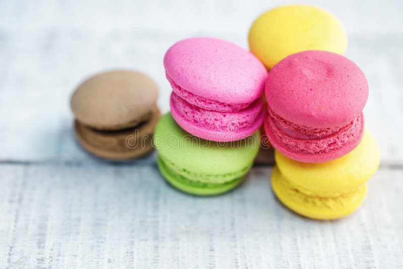 Macarons coloridos vibrantes en la tabla de madera blanca fotografía de archivo libre de regalías Macarons coloridos vibrantes en la tabla de madera blanca fotografía de archivo libre de regalías