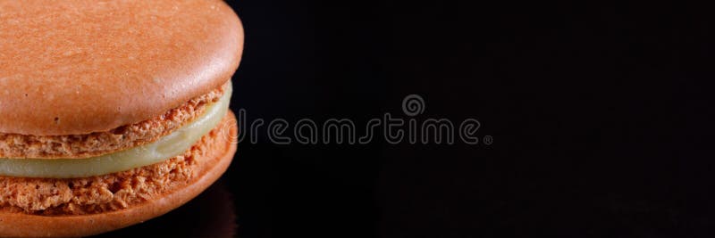 Macarons délicieux juteux lumineux de couleur sensible sur un fond noir drapeau photos stock Macarons délicieux juteux lumineux de couleur sensible sur un fond noir drapeau photos stock