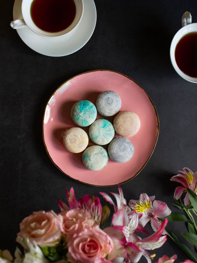 Macarons multicolores en la placa rosada en una tabla oscura taza blanca de té o de café desayuno con el postre Ramo de flores fotografía de archivo Macarons multicolores en la placa rosada en una tabla oscura taza blanca de té o de café desayuno con el postre Ramo de flores fotografía de archivo