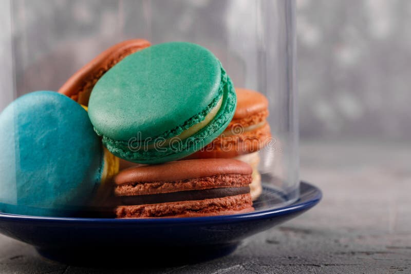 Macarons multicolores sous le dôme en verre Macarons sensibles de macarons image stock Macarons multicolores sous le dôme en verre Macarons sensibles de macarons image stock
