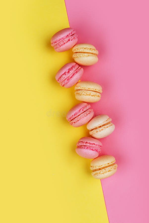 Macarons sur le jaune - le fond rose s'est divisé diagonalement en deux triangles image libre de droits Macarons sur le jaune - le fond rose s'est divisé diagonalement en deux triangles image libre de droits