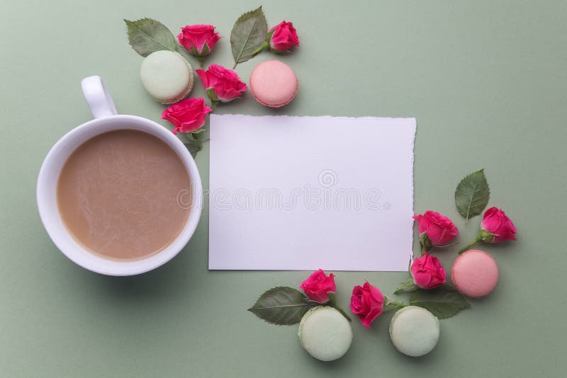 Macaroons, coffee and rose on green background. Top view. Flat lay