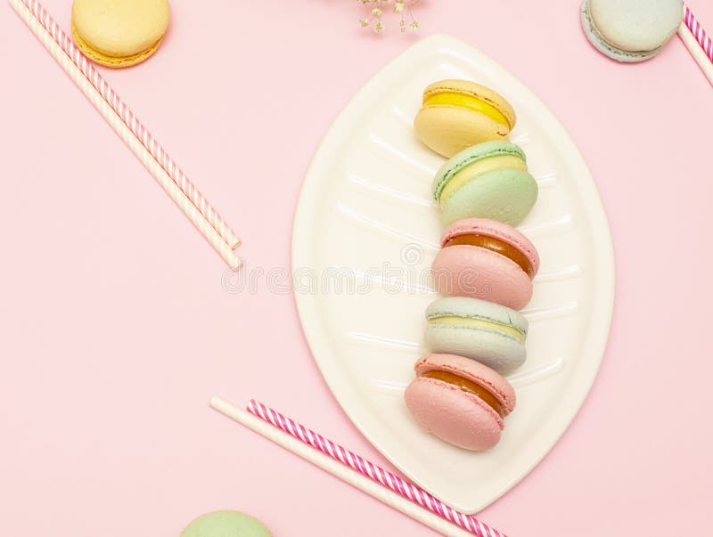 Macaroons свежего яркого cfresh яркие розовые или macaroons на белой тарелке в folored macarons или macaroons на розовой фон. Свежие яркие розовые macaroons или macaroons на белой тарелке в виде лист. Вокруг бумажных tubules для напитков. На фоне роз с пространством копии.