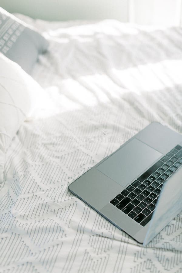 Macbook pro sentado na cama imagens de stock
