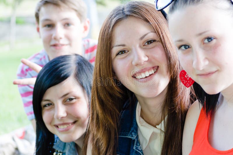 Macchina fotografica adolescente degli amici sorridere felice & esaminare dei giovani su estate all'aperto fotografia stock Macchina fotografica adolescente degli amici sorridere felice & esaminare dei giovani su estate all'aperto fotografia stock