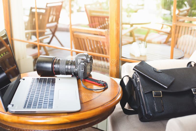 Macchina fotografica del dslr e del computer portatile al caffè fotografia stock libera da diritti Macchina fotografica del dslr e del computer portatile al caffè fotografia stock libera da diritti